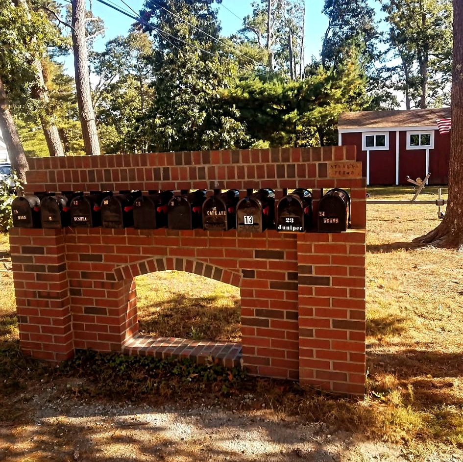 Custom brick mailbox structure with arched opening by Adams Masonry